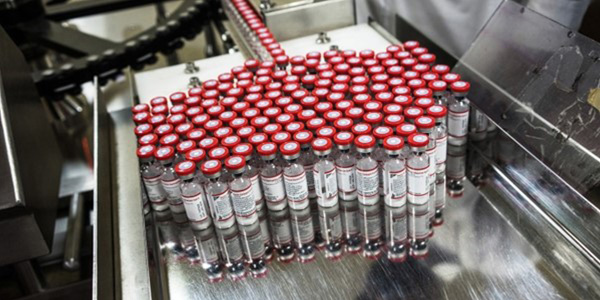 Vaccines exit a vial monitor-labelling machine at the Serum Institute of India's pharmaceutical plant in Pune, Maharashtra, India, on 4 May 2015. (Photo: Sanjit Das / Bloomberg via Getty Images)